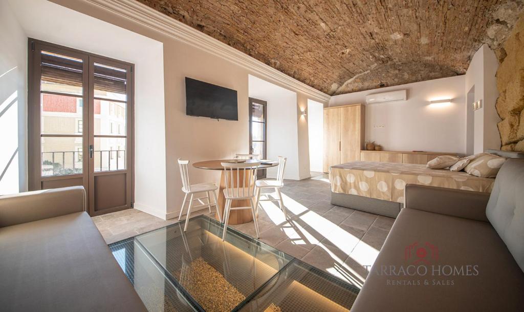 a bedroom with a bed and a table in a room at Apartamentos Boutique Murmur in Tarragona