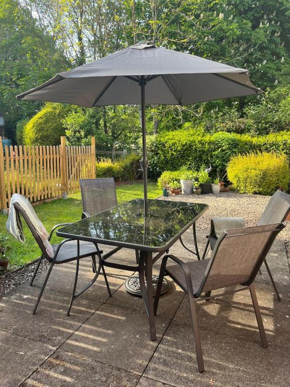 a table and two chairs with an umbrella at Hanley Swan, The Garden Flat in Madresfield