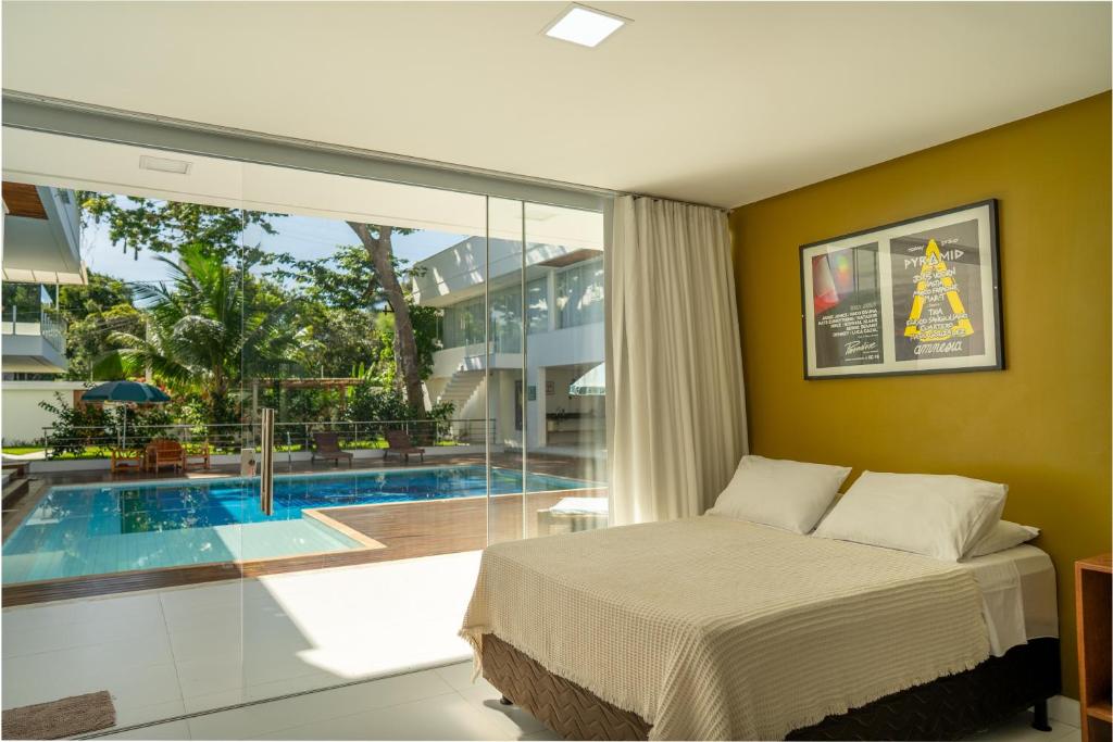 una camera da letto con un letto e una piscina di Pousada Corais de Ibiza a Arraial d'Ajuda