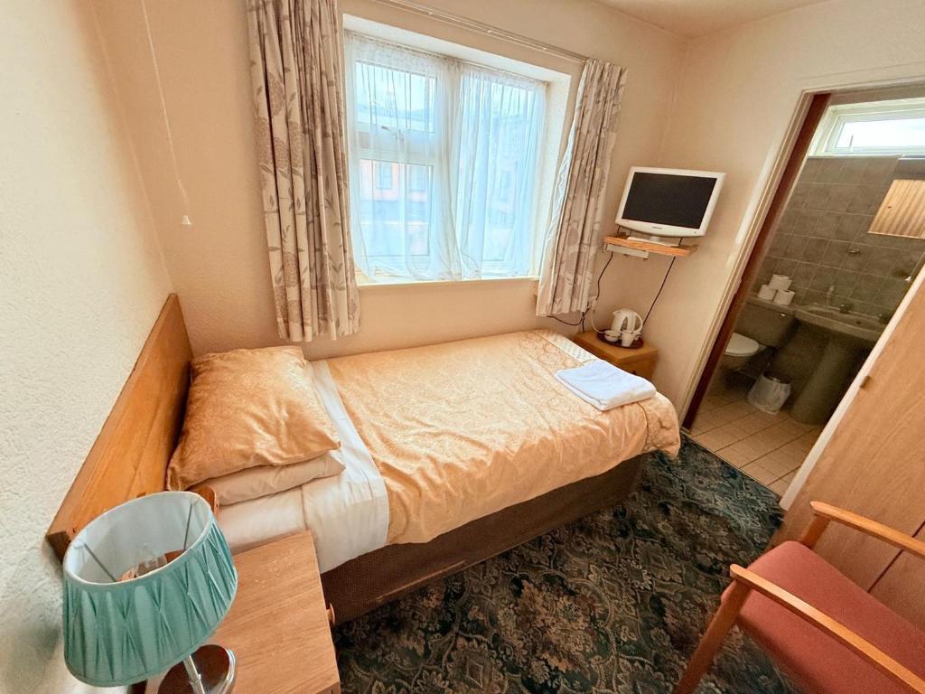 a small bedroom with a bed and a window at Hylands Hotel Single Ensuite Room with Free Parking in Nottingham