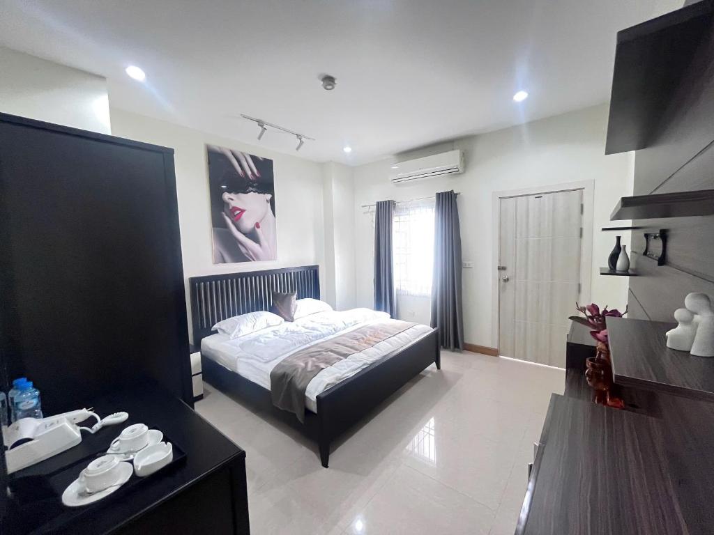 a bedroom with a bed and a desk in a room at Paradise Hotel & Apartment in Vientiane