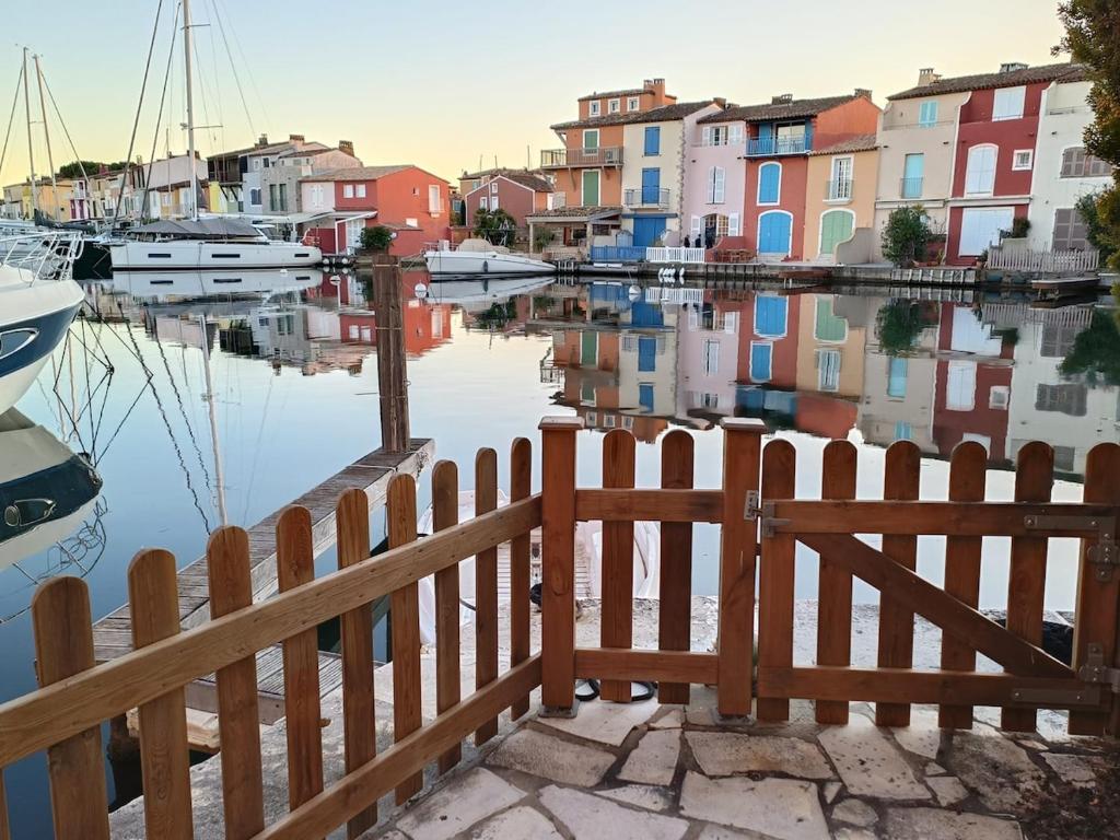 a wooden fence next to a body of water with boats at Fisherman's house in Port Grimaud in Grimaud