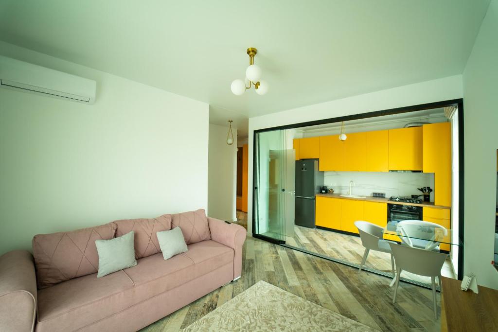 a living room with a pink couch and a kitchen at CristAlex Sunset in Constanţa