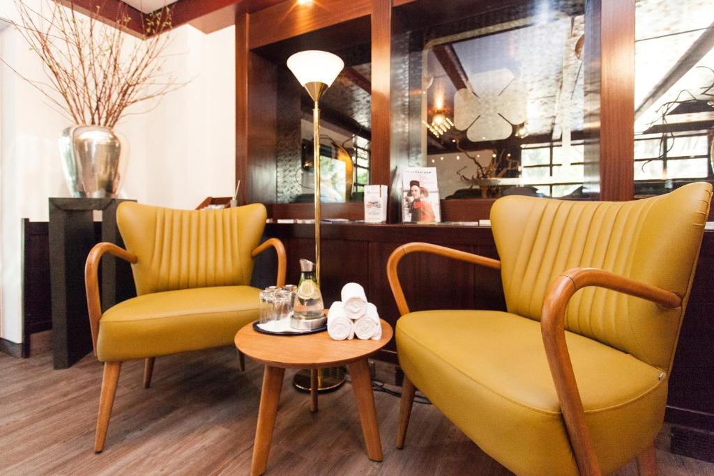 duas cadeiras amarelas e uma mesa num restaurante em Trip Inn Klee am Park Wiesbaden em Wiesbaden
