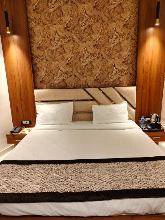 a bedroom with a white bed with a wall at The Monark Inn in Sandīla