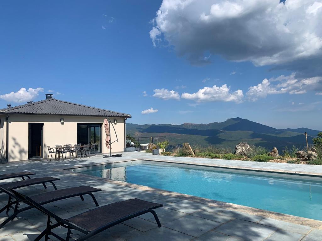 a swimming pool with two chairs next to a house at Villa H in Casanova