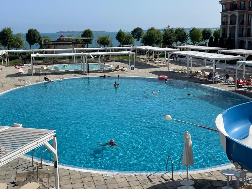 a large swimming pool with people swimming in it at Premier Fort Beach-Luxury Studio-First Line Resort in Sveti Vlas
