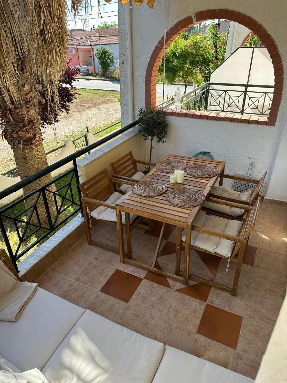 カリテア・ハルキディキにあるAgapi Apartment Kalitheaの木製テーブルと椅子付きのバルコニーから眺めの良い景色を楽しめます。
