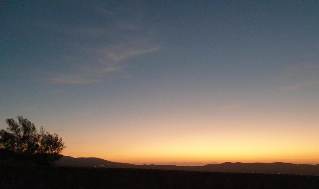 una puesta de sol en las montañas con un árbol en primer plano en Casa Fayacanes, en La Ampuyenta