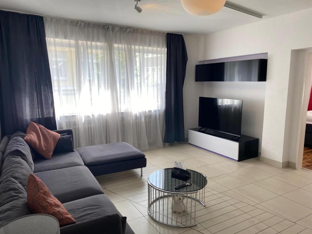 ein Wohnzimmer mit Sofa und Fernseher in der Unterkunft XXL-Cologne Cathedral Apartment in Köln