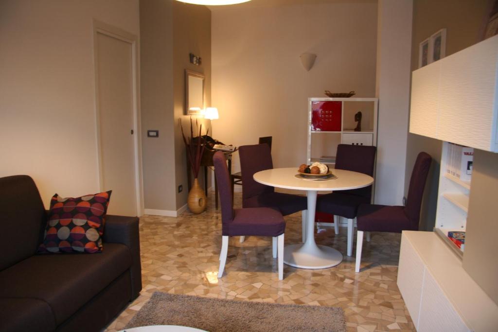sala de estar con sofá, mesa y sillas en Chez Nous, en Milán
