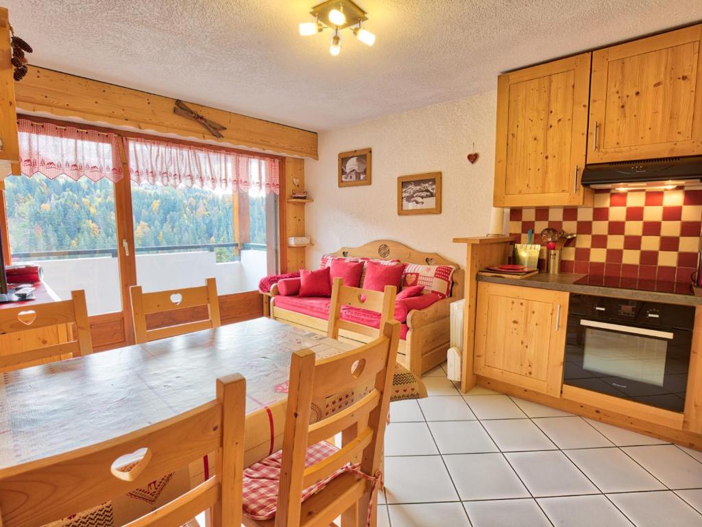 une cuisine et un salon avec une table et un canapé dans l'établissement Charmant appartement familial avec parking et animaux acceptés - FR-1-505-63, à Notre-Dame-de-Bellecombe