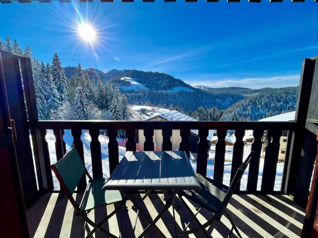 d'un banc sur un balcon avec vue sur les montagnes. dans l'établissement Charmant studio au pied des pistes, animaux admis - FR-1-505-79, à Notre-Dame-de-Bellecombe