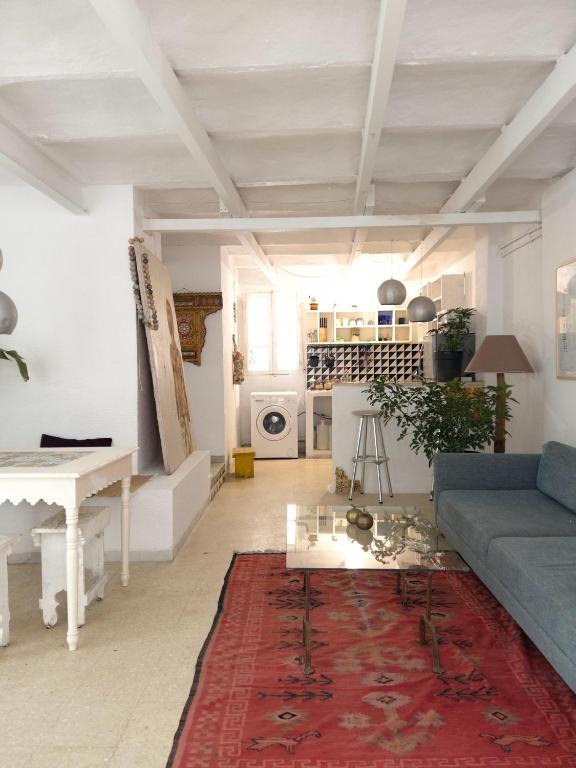 迦太基La maison de oiseaux的客厅里有一张蓝色的沙发和一块红色的地毯