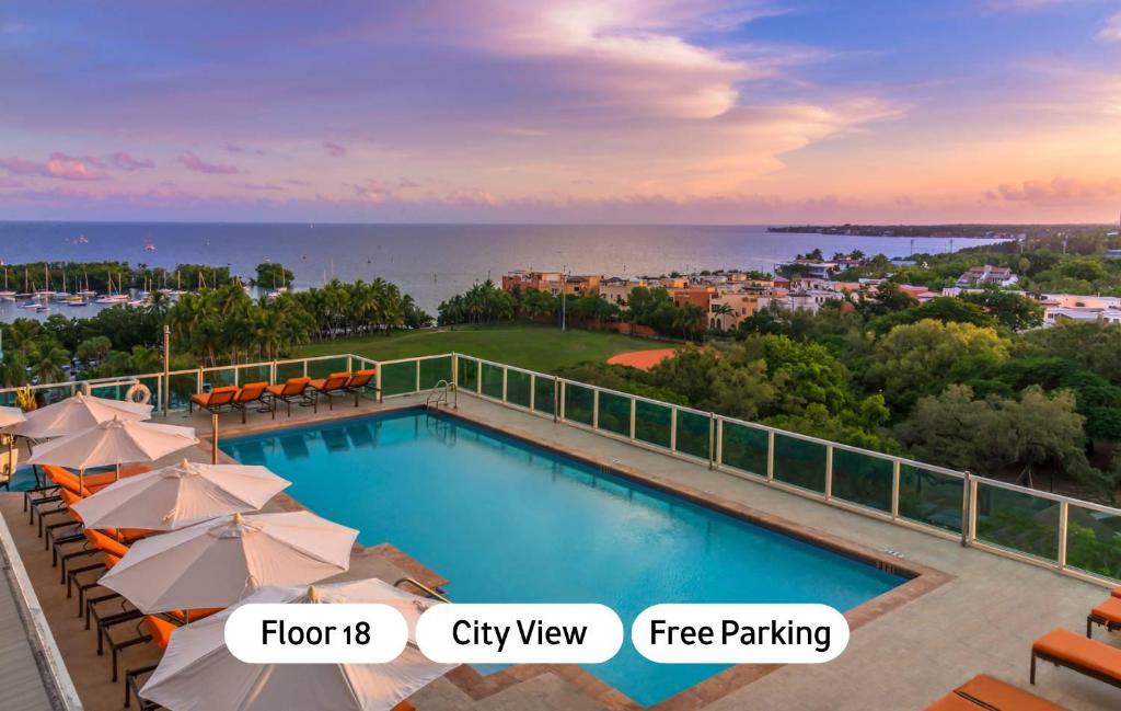 a swimming pool with umbrellas and a view of the ocean at MVR Suite Boutique Living with Big Luxury Energy in Miami