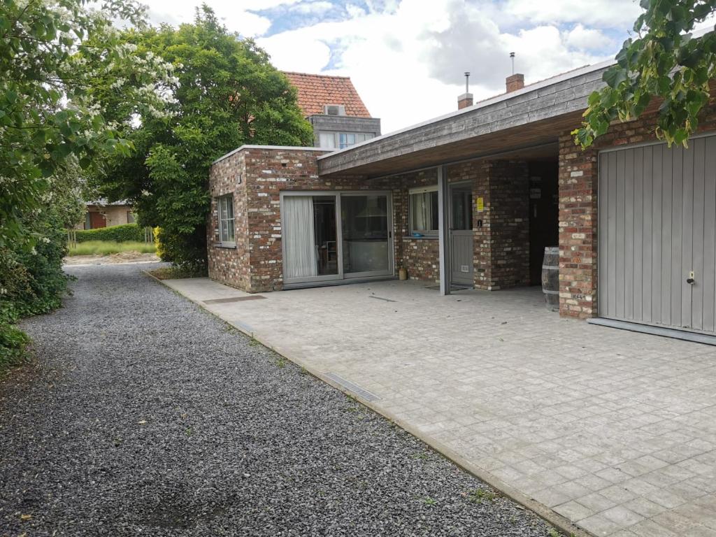 a brick house with a garage and a driveway at Vakantiewoning Henri Vleteren-Ieper in Woesten