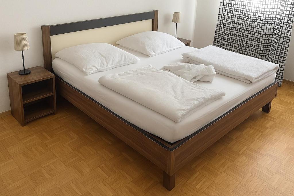 a large bed with white sheets and pillows on it at Apartment 8 at Cologne Cathedral in Cologne