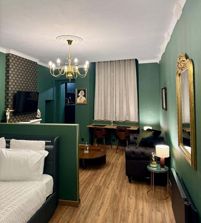 - une chambre avec des murs verts, un lit et une table dans l'établissement Le Repère Royal Blois, Hypercentre, à Blois