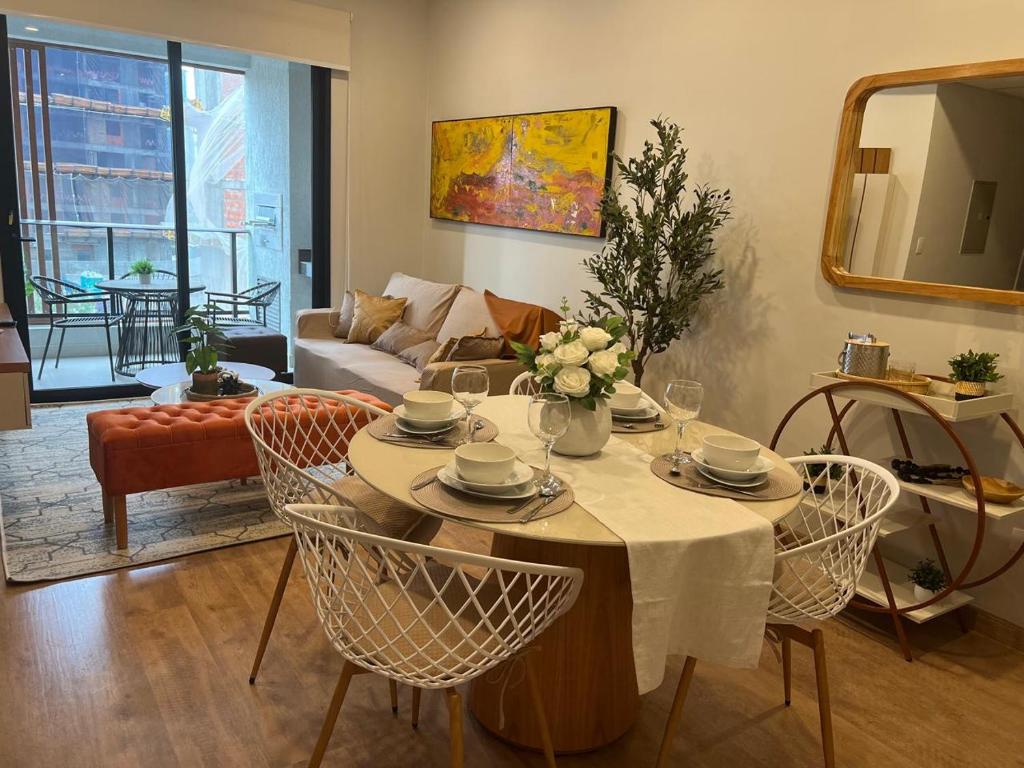 a living room with a table with chairs and a couch at Luxurious 2 Bed Apt W Gym & Pool In Villa Morra in Asuncion