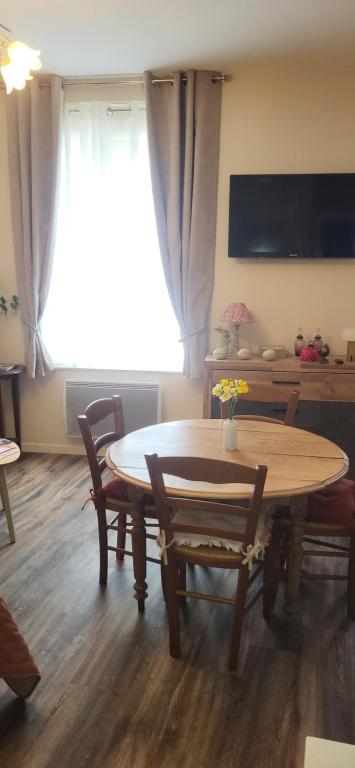 une salle à manger avec une table et des chaises et une fenêtre dans l'établissement Au coeur de Marie, à Aire-sur-la-Lys