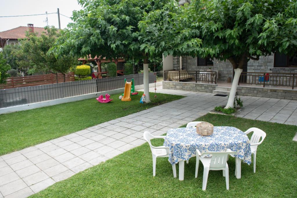 una mesa y sillas en un patio con un árbol en Family house nea vrasna, en Nea Vrasna