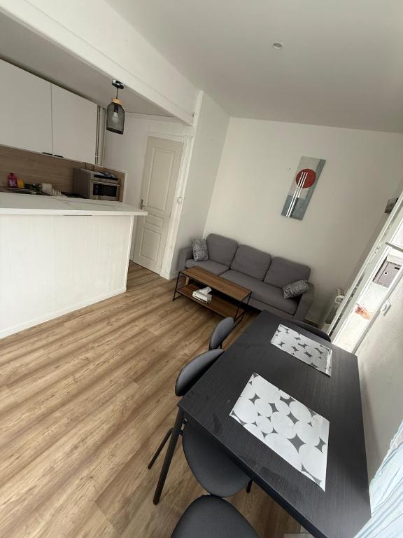 un salon avec un canapé et une table dans l'établissement Maison de ville cosy pour 4 personnes, à Grand-Couronne