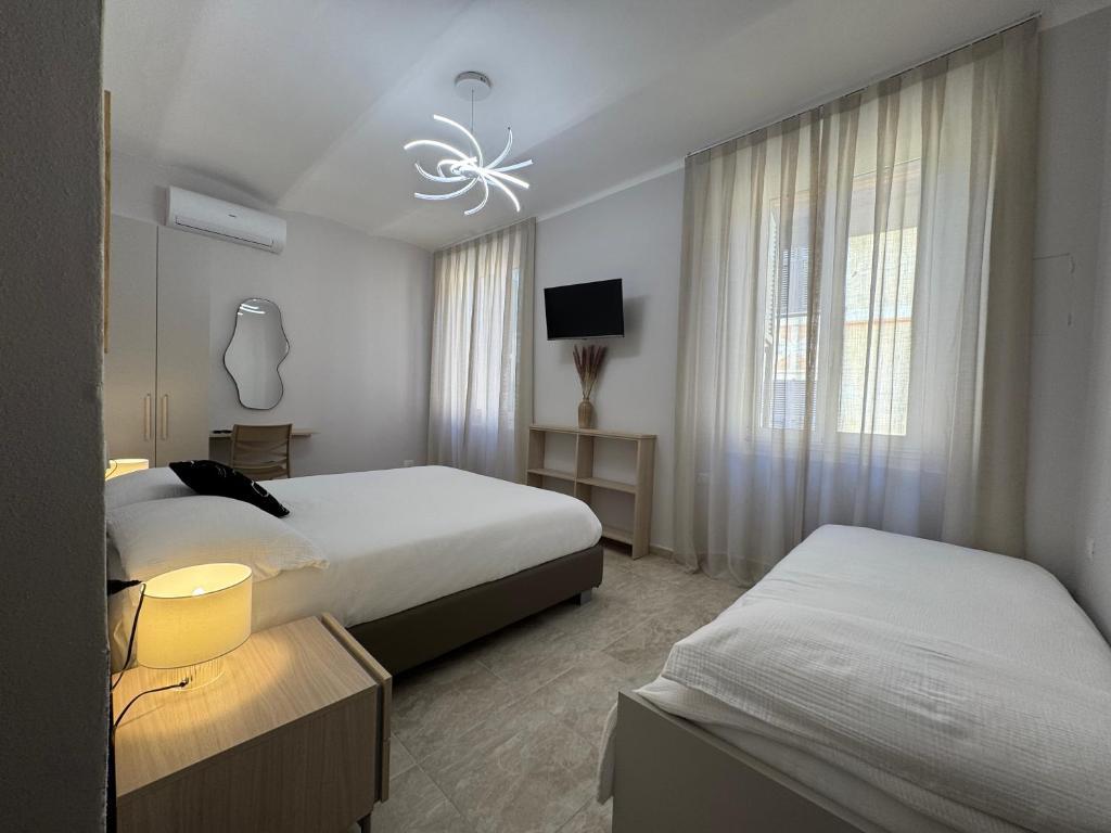 a hotel room with two beds and a television at Paola HOME in Varazze