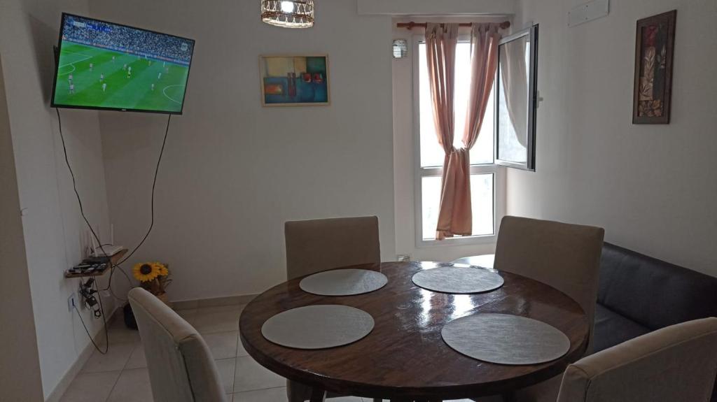 a dining room table with chairs and a television on the wall at Casita de Tucuman in San Miguel de Tucumán