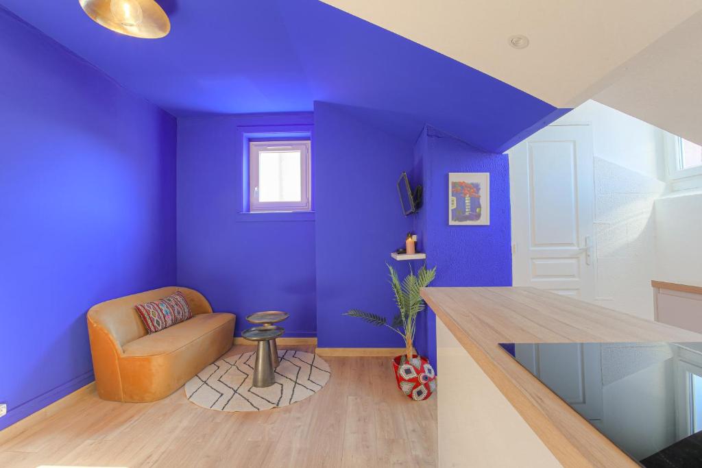 - un salon avec des murs violets et une chaise dans l'établissement IDÉAL Pro & Couples - Calme- Dernier Etage - Cité des Affaires, à Saint-Étienne