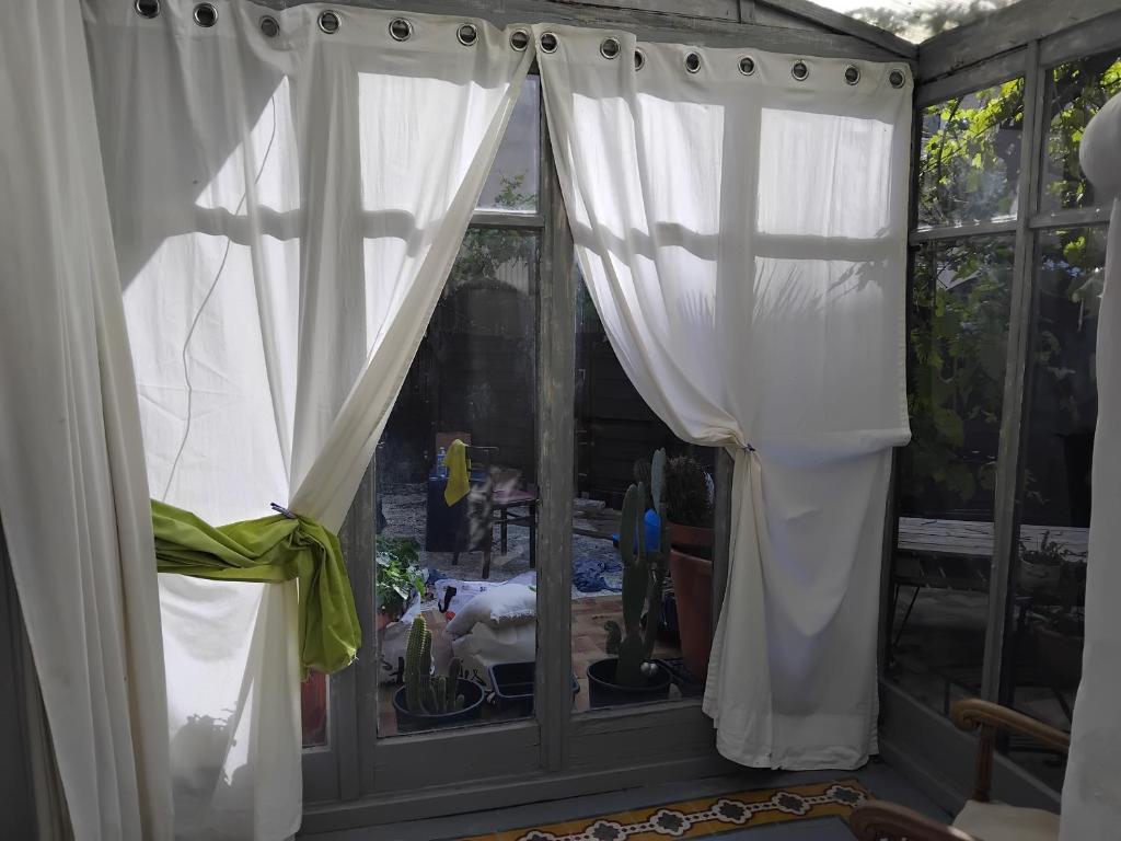 Cette chambre dispose d'une fenêtre avec des rideaux blancs. dans l'établissement Maison authentique, à Nice