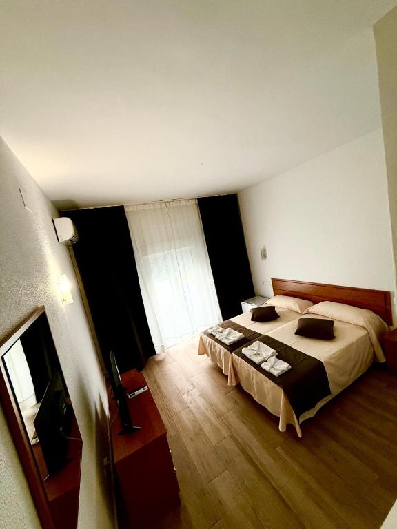 Un dormitorio con dos camas y una gran ventana. en Costa De La Luz, en Huelva