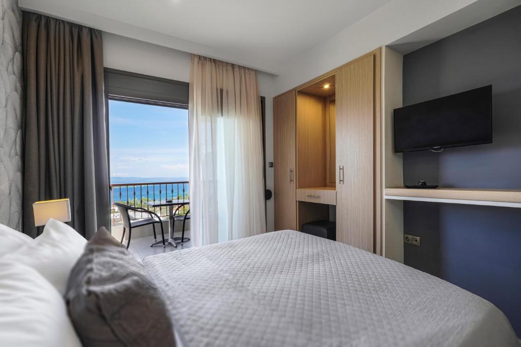 a hotel room with a bed and a balcony at Panorama Dream Studios B in Vourvourou