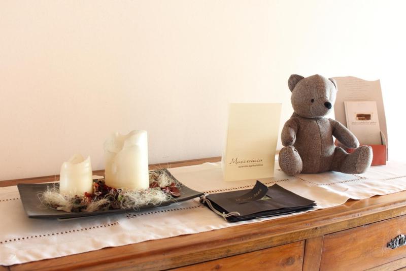 a teddy bear sitting on a table with candles at Agriturismo Mazzeracca in Bassano del Grappa