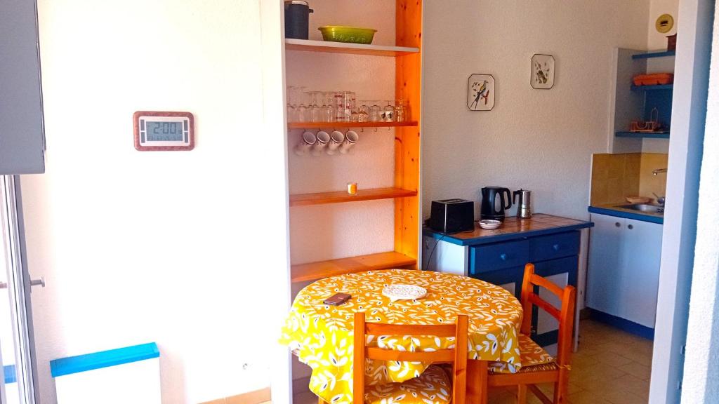 une petite cuisine avec une table et une table et des chaises dans l'établissement Dog Family House, à Cavalaire-sur-Mer