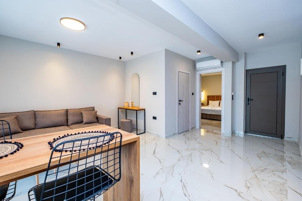 Una sala de estar con un sofá y un dormitorio. en Meraki Hospitality, en Polychrono
