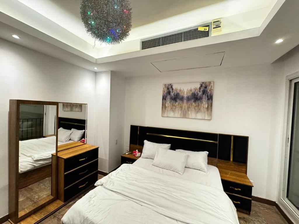 une chambre avec un grand lit et un miroir dans l'établissement فيلا داخل كمبواند ويستاون بيفرلي هيلز الشيخ زايد رقم هاتف صفر صفر اتنين صفر واحد واحد صفر اتنين اربعه ثلاثه صفر 222, à Sheikh Zayed