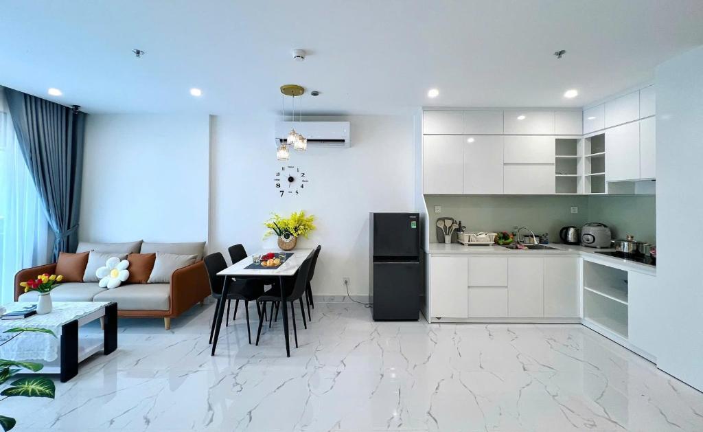 a kitchen and a living room with a couch and a table at An Nhiên Homes 1PN View Đẹp Check-in Tự Do Gần Vincom Mega Mall1316 in Gò Công