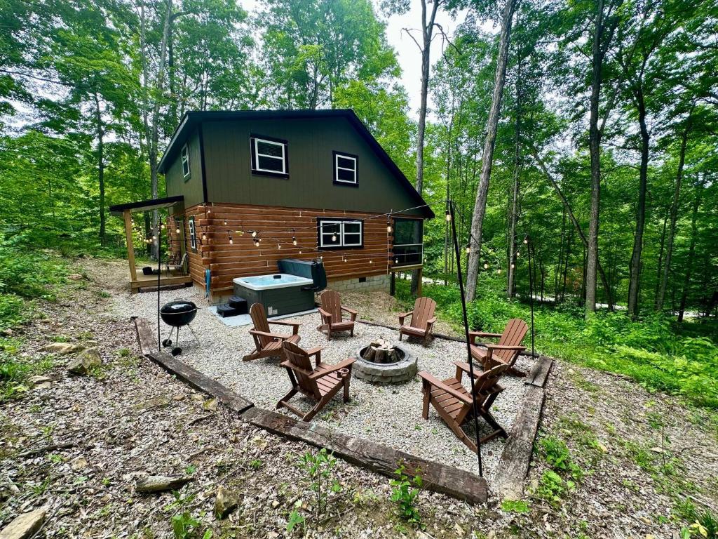 a cabin in the woods with chairs and a fire pit at Boulder Ridge Cabin in Eckerty