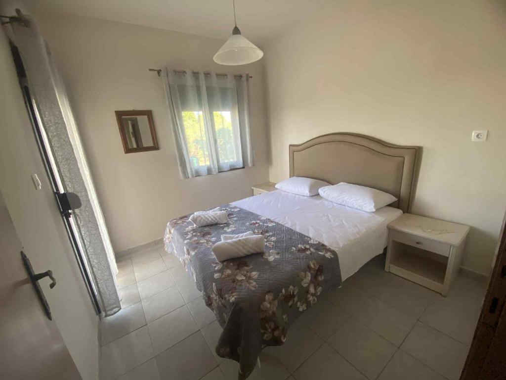 a bedroom with a bed and a window at Eleftheria House in Vourvourou