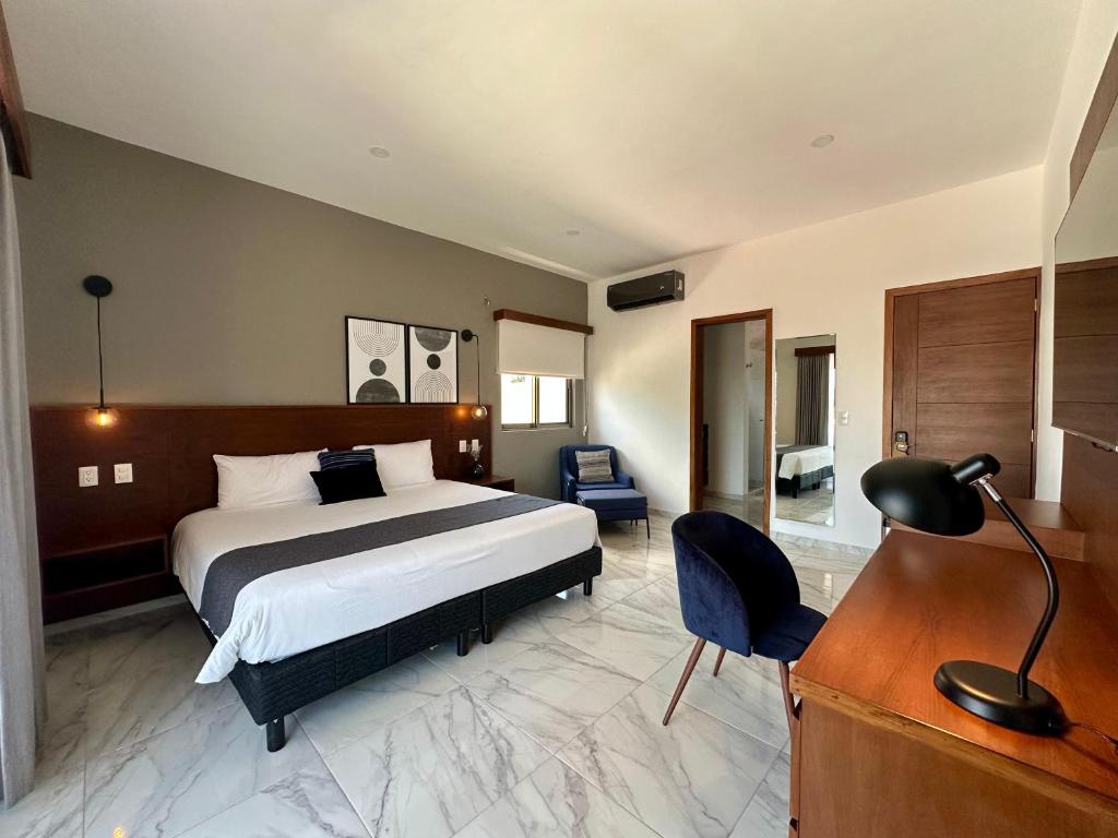 Una habitación de hotel con una cama y un escritorio y un escritorio. en Pachamaya Executive Wellbeing, en Cancún