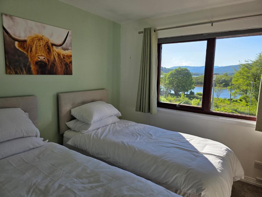 a bedroom with two beds and a large window at Linnhe View Fort William in Fort William