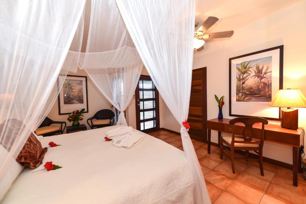 a bedroom with a bed and a desk at Victoria House Resort & Spa in San Pedro