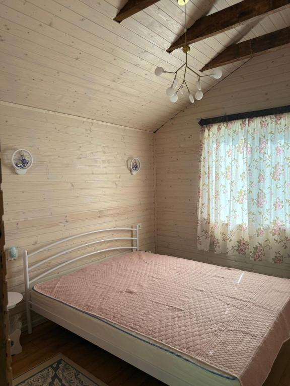 Un dormitorio con una cama en una habitación con ventana. en Holiday Home Near FOREST, en Skhidnytsya