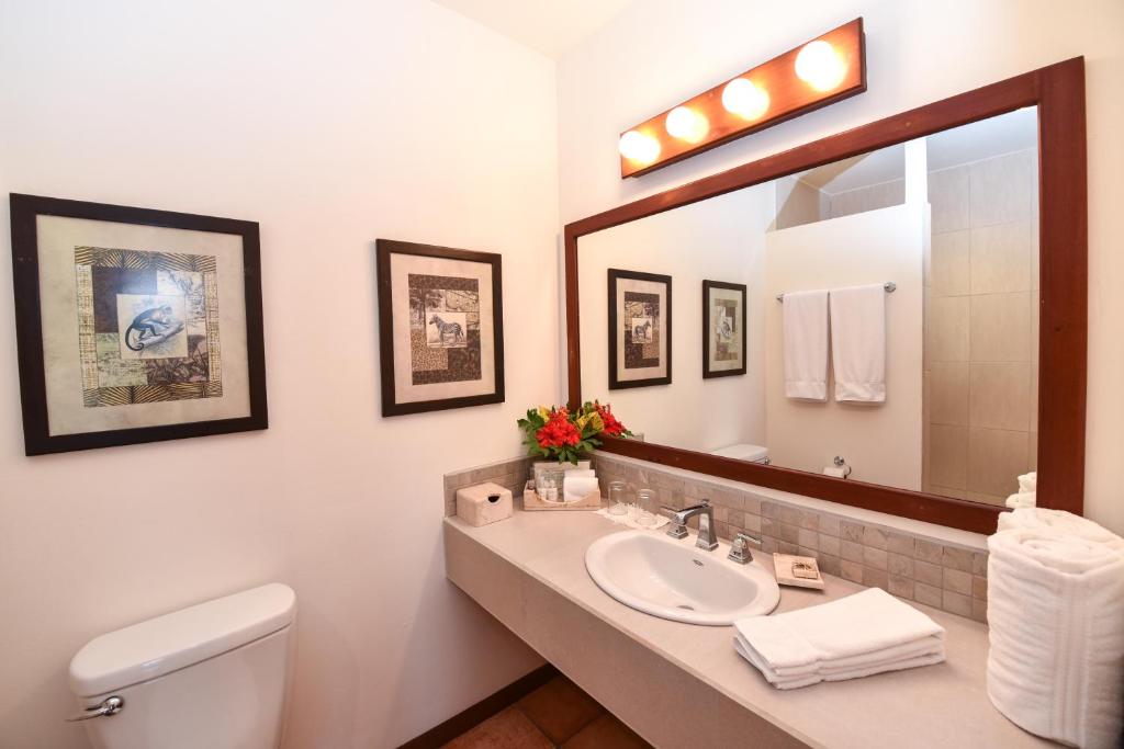 a bathroom with a sink and a mirror at Victoria House Resort & Spa in San Pedro