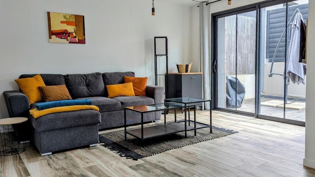un salon avec un canapé et une table en verre dans l'établissement BnB de Nomeny, cozy near train station, à Vannes