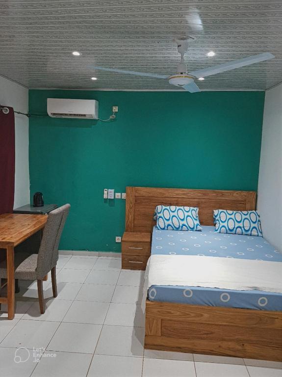 a bedroom with a bed and a green wall at La Résidence in Lomé