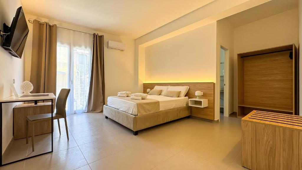 a bedroom with a bed and a desk and a television at Tevergad Premium Rooms in Terrasini
