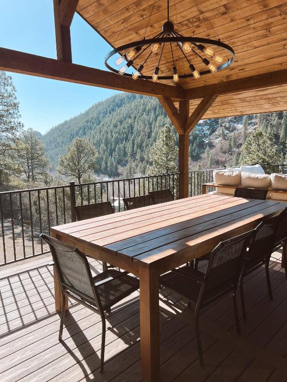 una mesa de madera y sillas en una terraza con vistas en Breathtaking View 12 Min to Downtown, en Durango