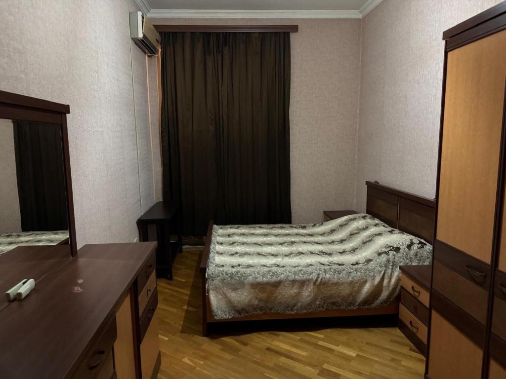 Un dormitorio pequeño con una cama y una cómoda. en Квартира в сердце Баку, en Baku