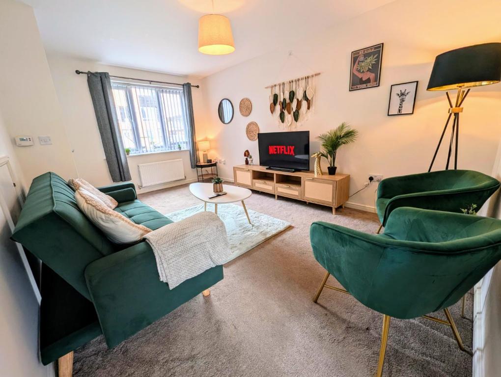un soggiorno con 2 sedie verdi e una TV di Steps from O2 Apollo, Ox road a Manchester